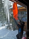 Chris being very careful to knock the massive icicles AWAY from the picture window.